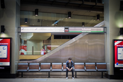 Benjamin assis sur un banc dans une station de métro.